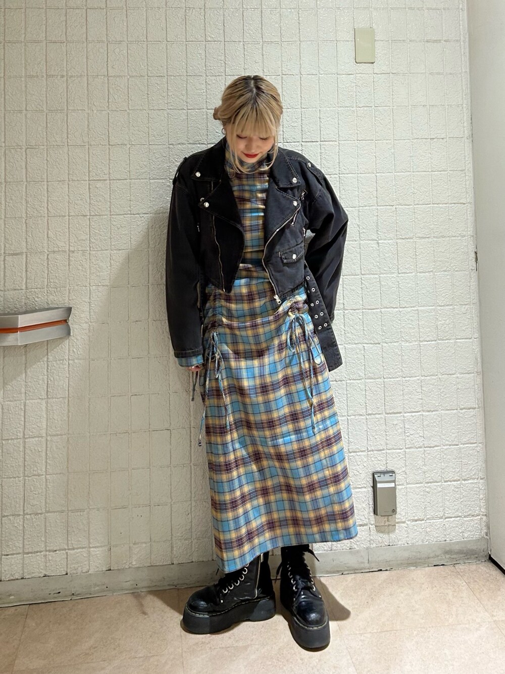 ブラック系のライダースジャケット、ブルー系のワンピース、ブラック系のその他シューズを着用したレディースの秋コーディネートの2枚目の写真