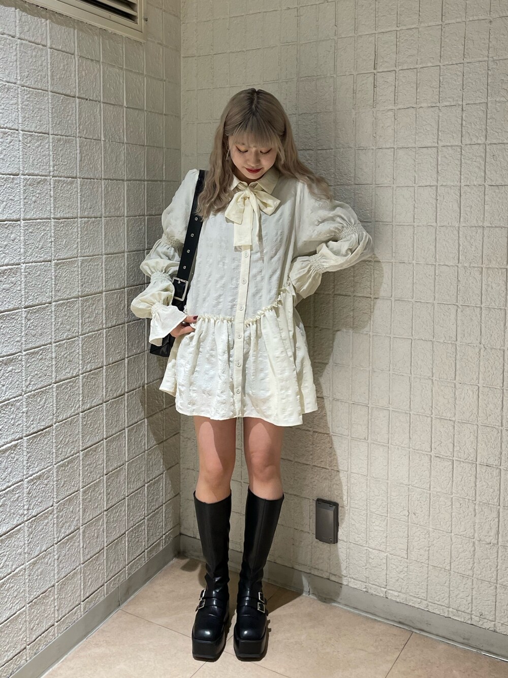 ブラック系のデニムパンツ、ホワイト系のシャツ/ブラウス、ブラック系のブーツを着用したレディースの冬コーディネートの2枚目の写真