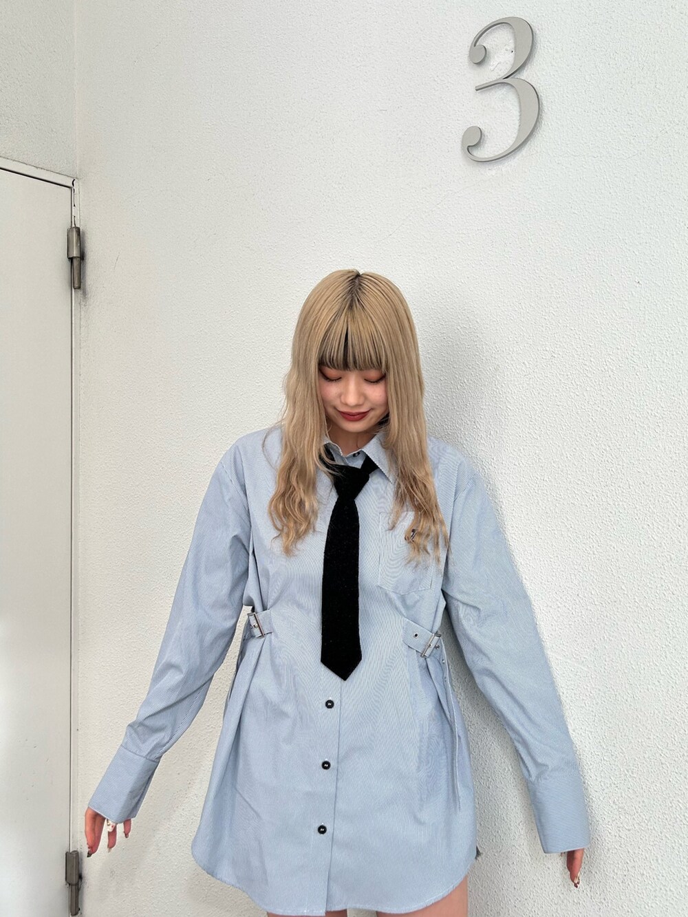 ブルー系のシャツ/ブラウス、ブラック系のデニムパンツ、ブラック系のブーツを着用したレディースの冬コーディネートの4枚目の写真