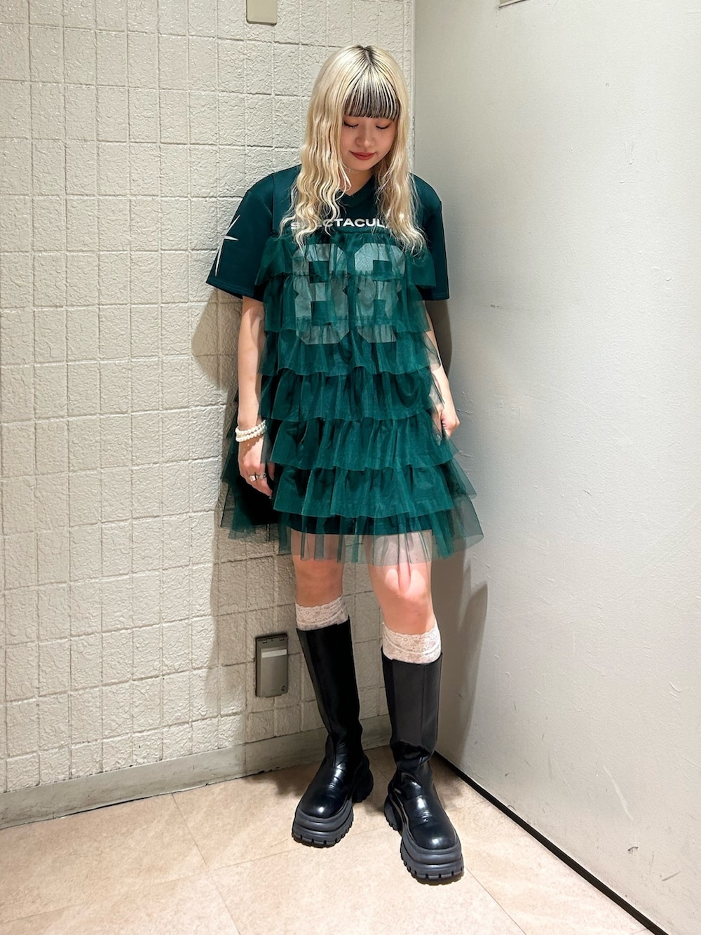 グリーン系のワンピース、ゴールド系のブレスレットを着用したレディースの春コーディネートの2枚目の写真