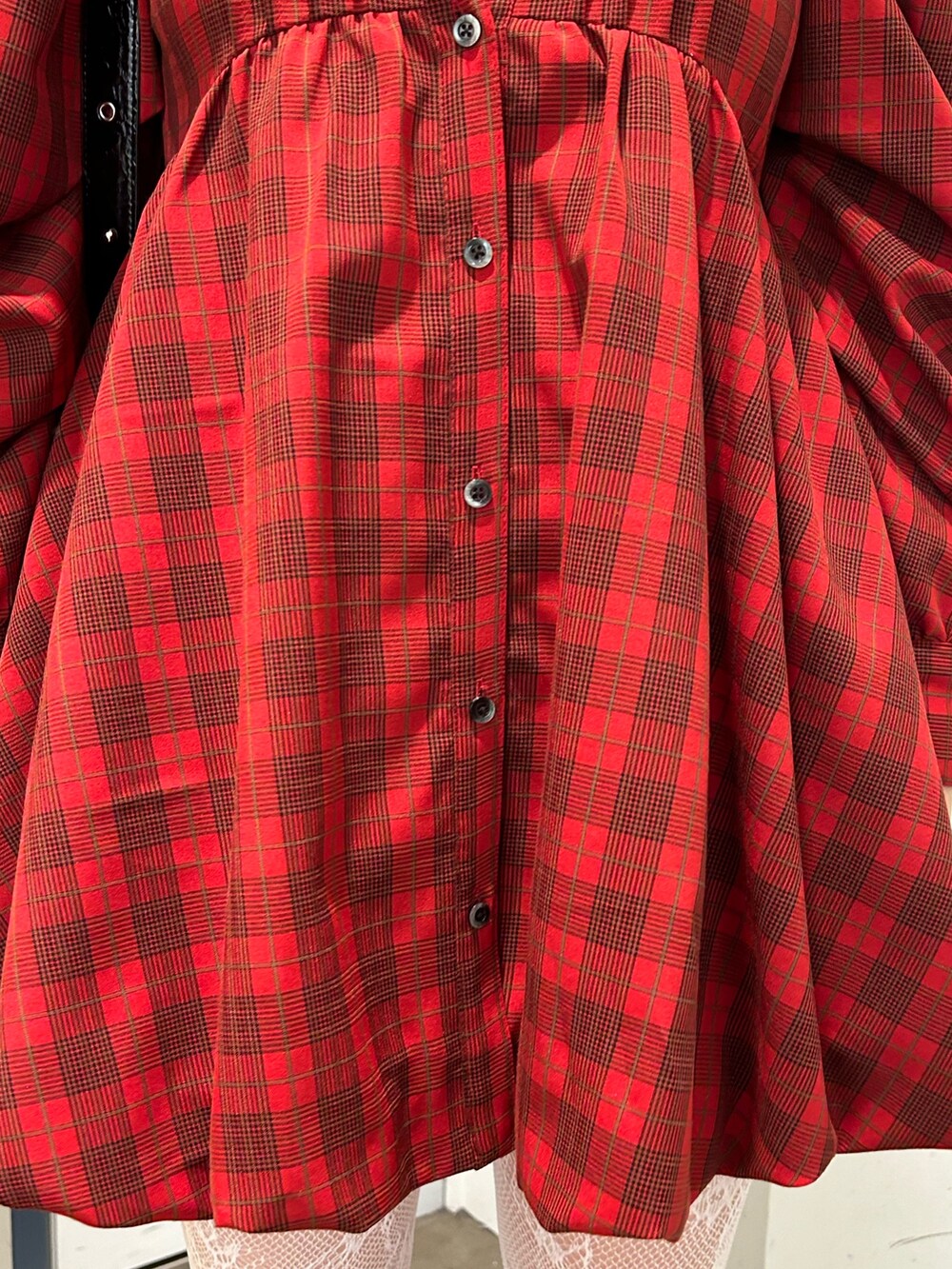 レッド系のワンピース、ブラウン系のブーツ、ブラック系のショルダーバッグを着用したレディースの夏コーディネートの8枚目の写真