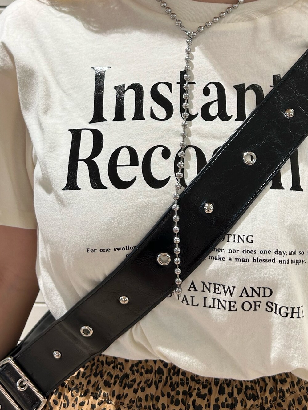 ブラウン系のスカート、ホワイト系のTシャツ/カットソー、ブラック系のショルダーバッグを着用したレディースの春コーディネートの5枚目の写真