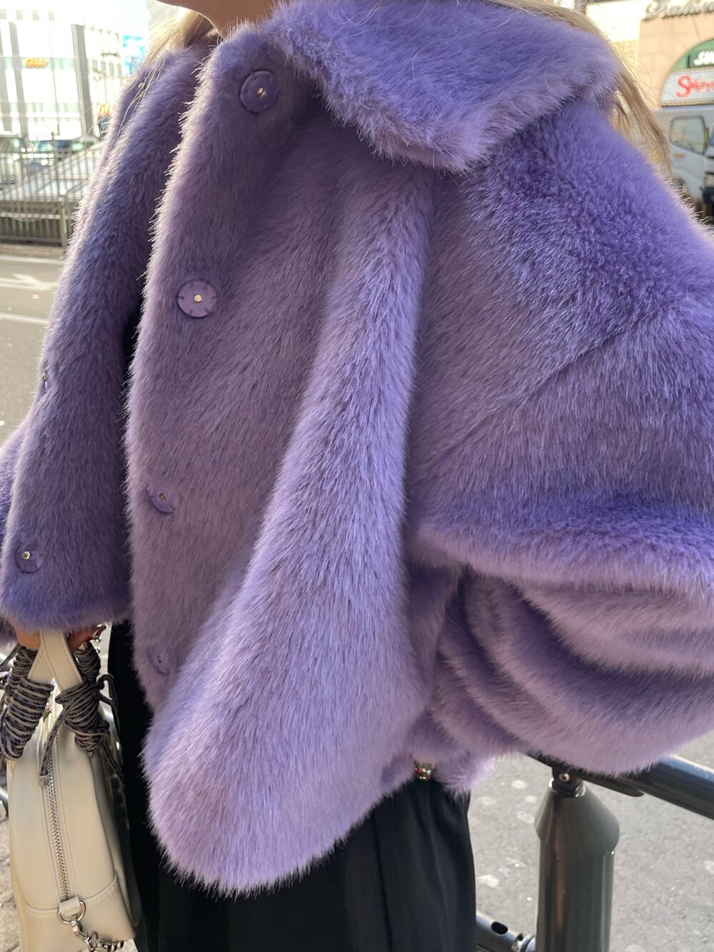 パープル系のその他アウター、ブラック系のワンピース、ブラック系のブーツを着用したレディースの冬コーディネートの6枚目の写真