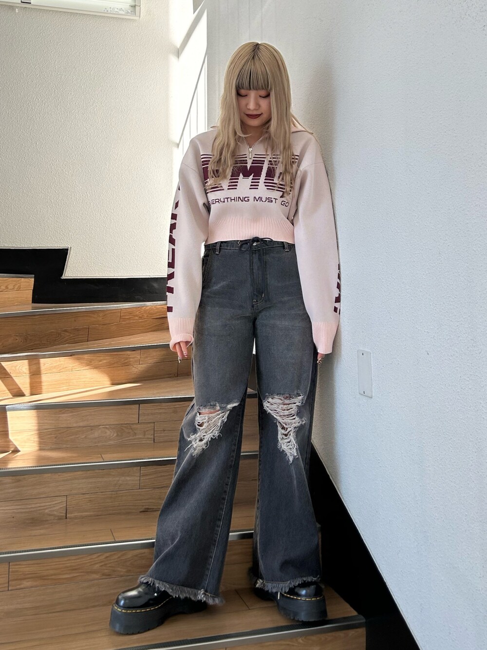 ピンク系のニット/セーター、ブラック系のデニムパンツ、ブラック系のその他シューズを着用したレディースの冬コーディネートの2枚目の写真