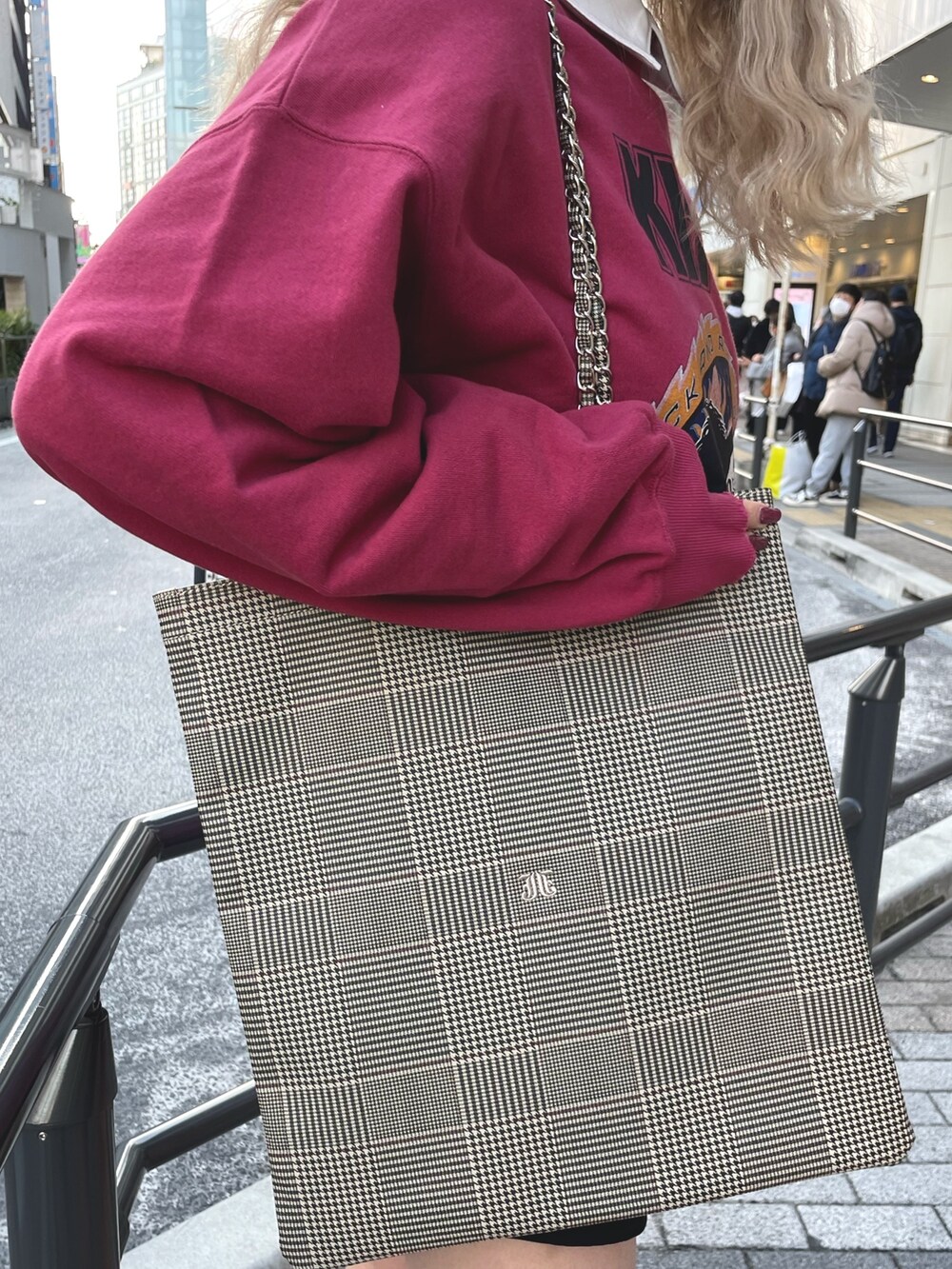 レッド系のスウェット、ブラック系のワンピース、ベージュ系のトートバッグを着用したレディースの冬コーディネートの6枚目の写真