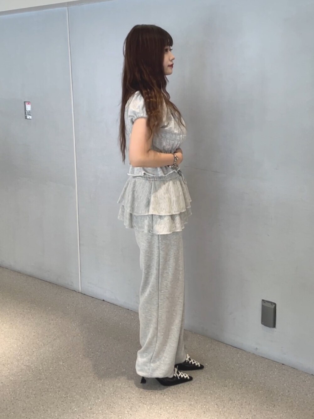 グレー系のTシャツ/カットソー、グレー系のスウェットパンツ、ブラック系のパンプスを着用したレディースの夏コーディネートの3枚目の写真