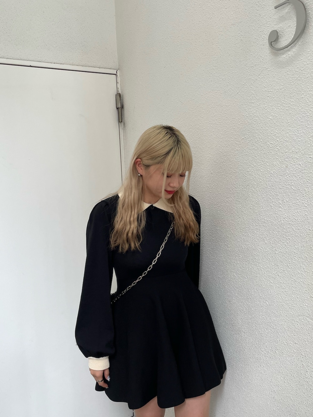 ブラック系のワンピース、ブラック系のハンドバッグを着用したレディースの夏コーディネートの2枚目の写真