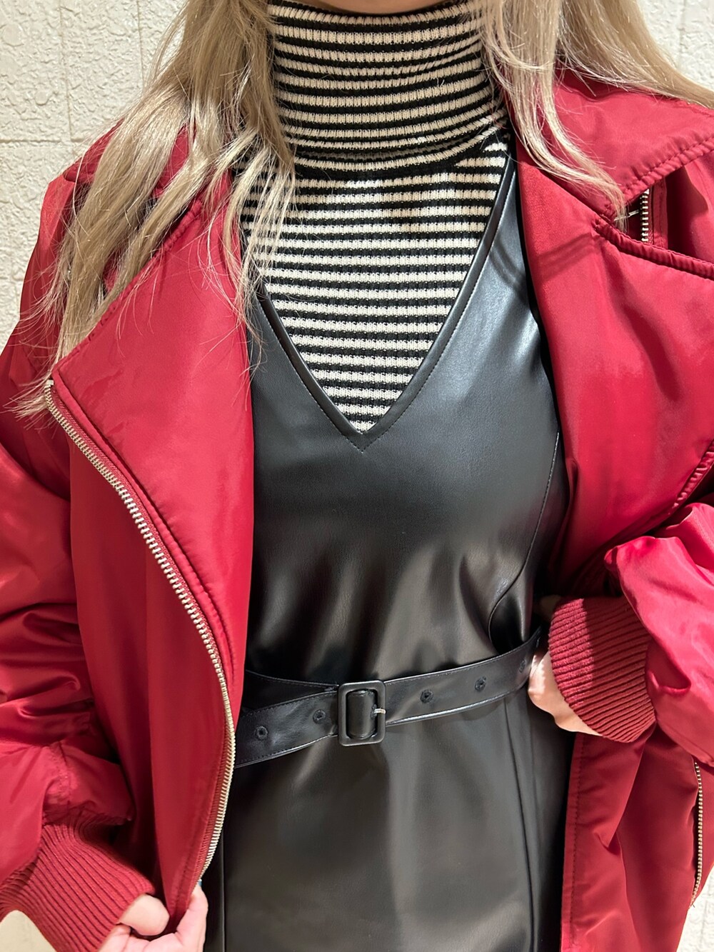 レッド系のMA-1、ブラック系のブーツ、ブラック系のジャンパースカートを着用したレディースの冬コーディネートの6枚目の写真