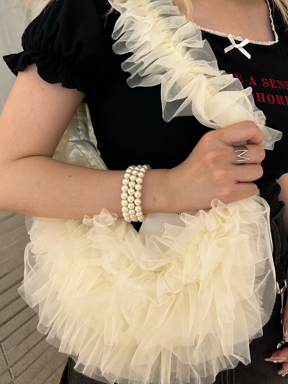 ブラック系のTシャツ/カットソー、ホワイト系のショルダーバッグ、ブラック系のデニムスカートを着用したレディースの夏コーディネートの8枚目の写真