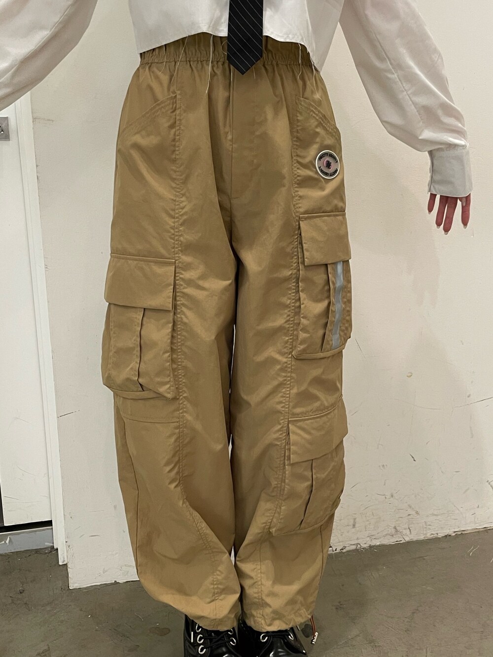 ホワイト系のシャツ/ブラウス、ベージュ系のカーゴパンツ、ブラック系のその他シューズを着用したレディースの夏コーディネートの6枚目の写真