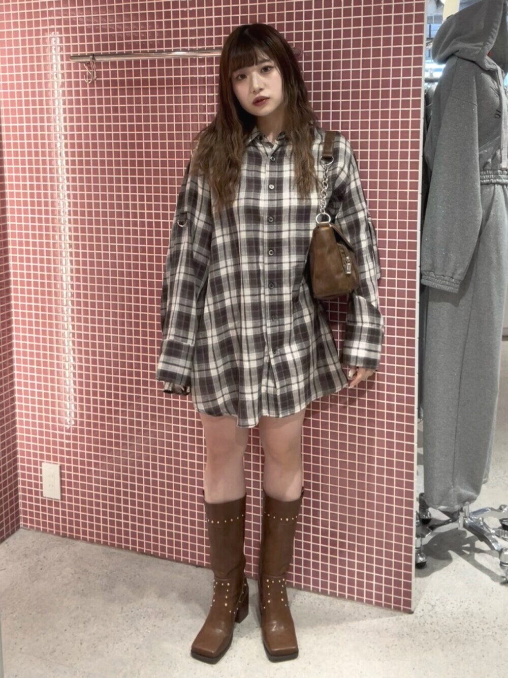 ブラウン系のシャツ/ブラウス、ブラウン系のハンドバッグ、ブラウン系のブーツを着用したレディースの春コーディネートの2枚目の写真