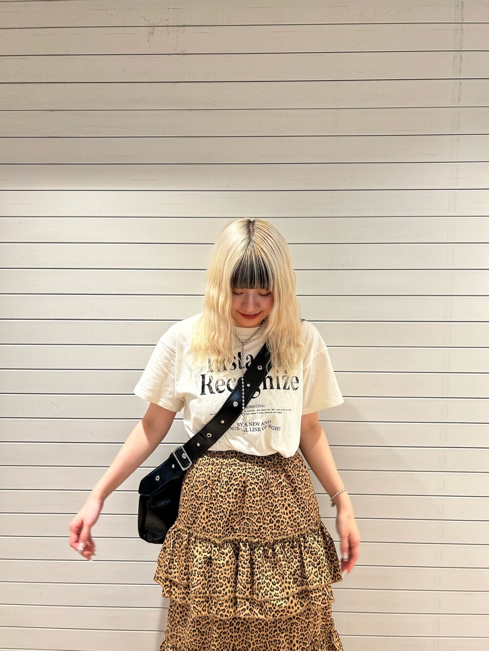 ブラウン系のスカート、ホワイト系のTシャツ/カットソー、ブラック系のショルダーバッグを着用したレディースの春コーディネートの4枚目の写真