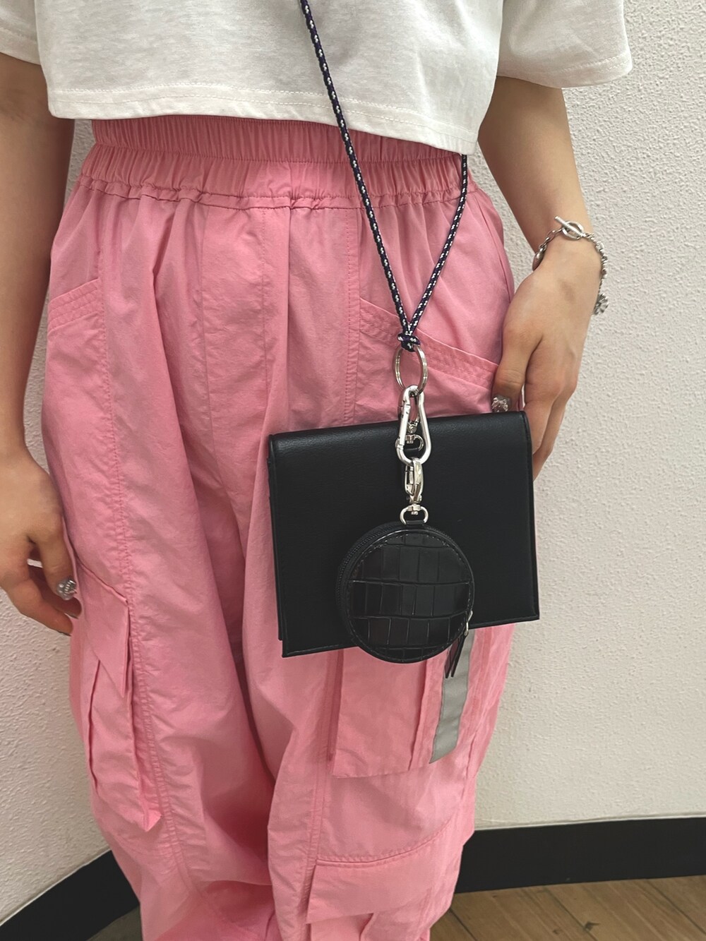 ピンク系のカーゴパンツ、ブラック系のその他シューズ、ホワイト系のTシャツ/カットソーを着用したレディースの春コーディネートの7枚目の写真