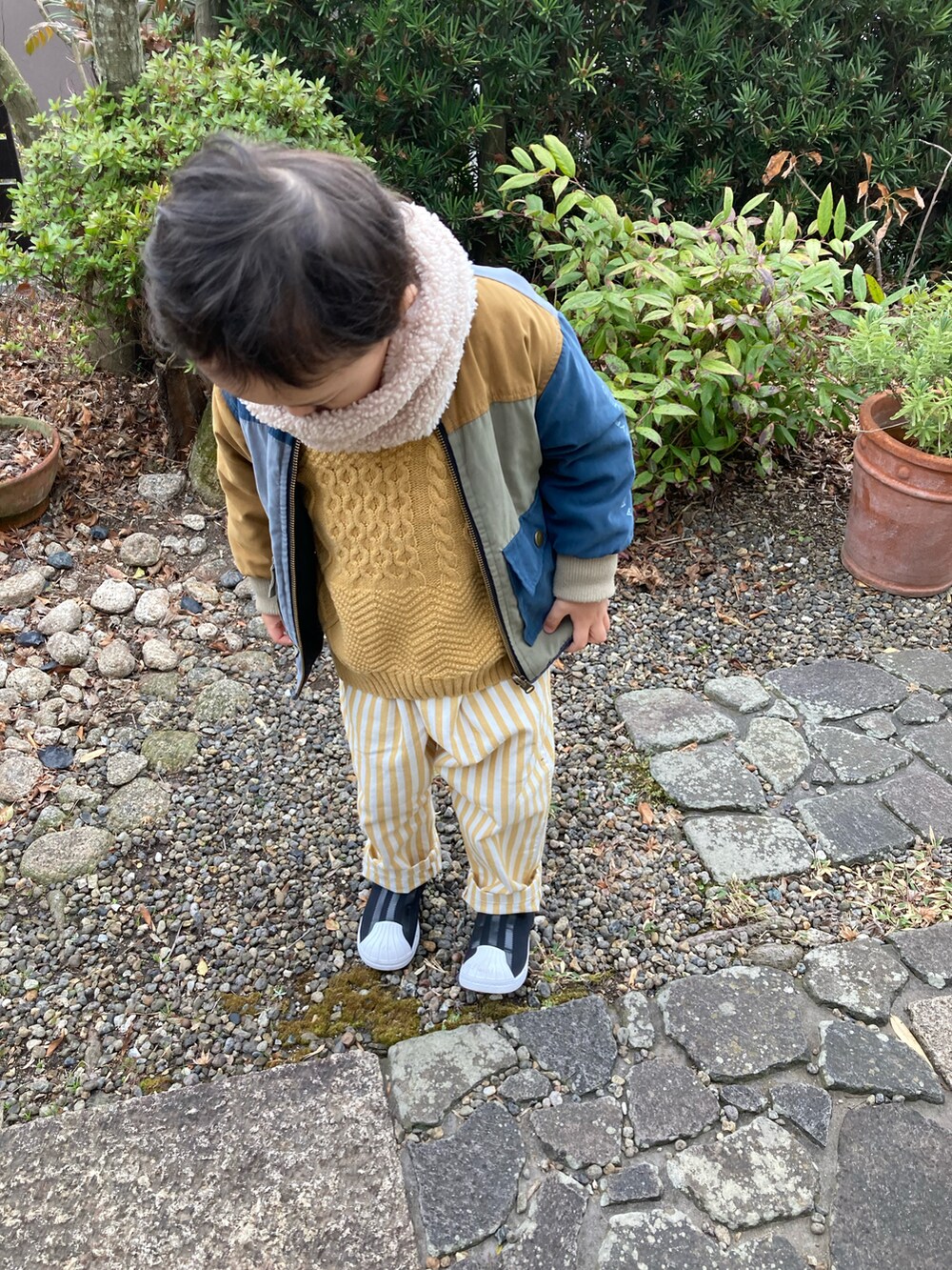 イエロー系のニット/セーター、その他のノーカラージャケット、イエロー系のその他パンツを着用したキッズの冬コーディネートの2枚目の写真