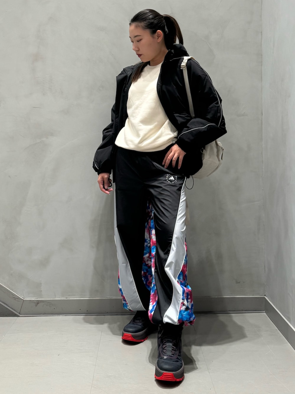 ブラック系のジャケット/アウター、ベージュ系のバッグ、ブルー系のパンツを着用したレディースの秋コーディネートの2枚目の写真