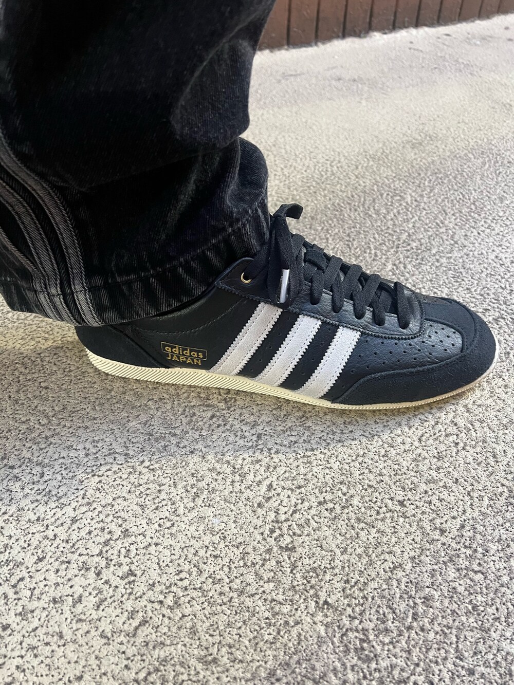 ブラック系のナイロンジャケット、ブラック系のシューズ、ブラック系のデニムパンツを着用したメンズの冬コーディネートの4枚目の写真