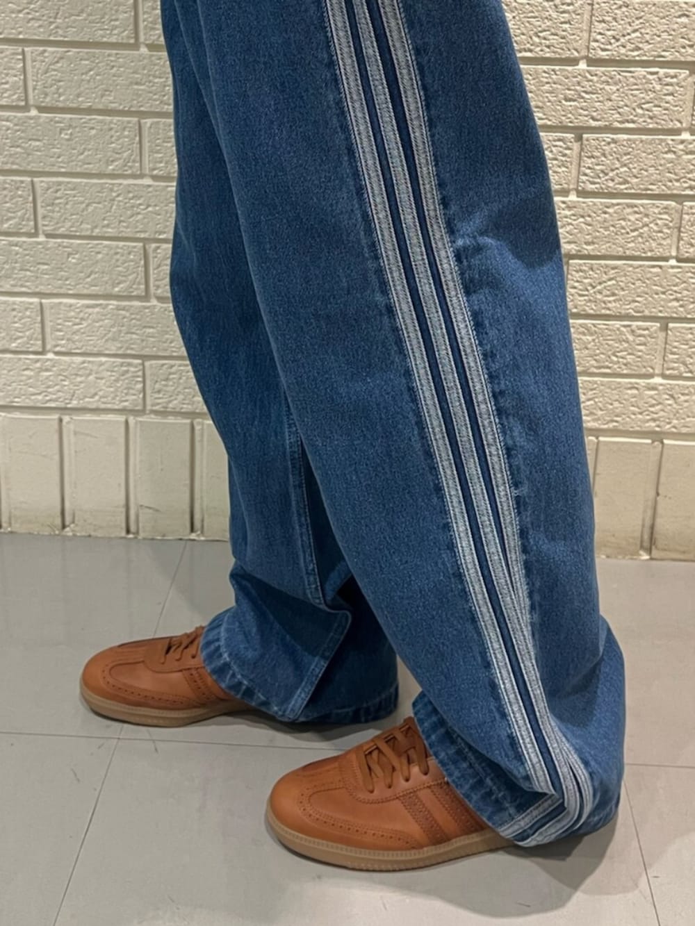 ブルー系のデニムパンツ、レッド系のシューズを着用したメンズの春コーディネートの3枚目の写真