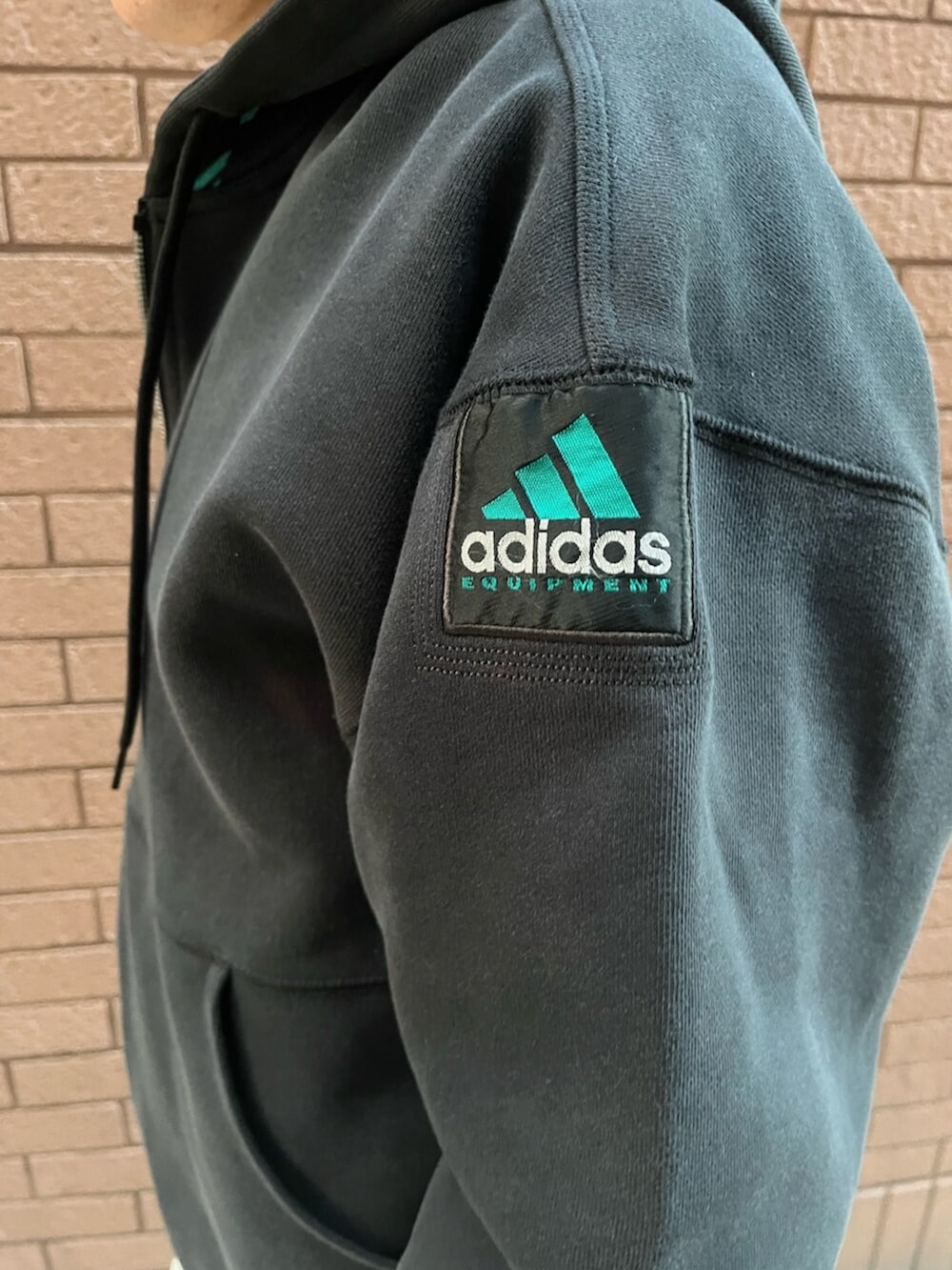 ブラック系のトップス、ブラック系のパンツ、ブラック系のスニーカーを着用したメンズの冬コーディネートの3枚目の写真