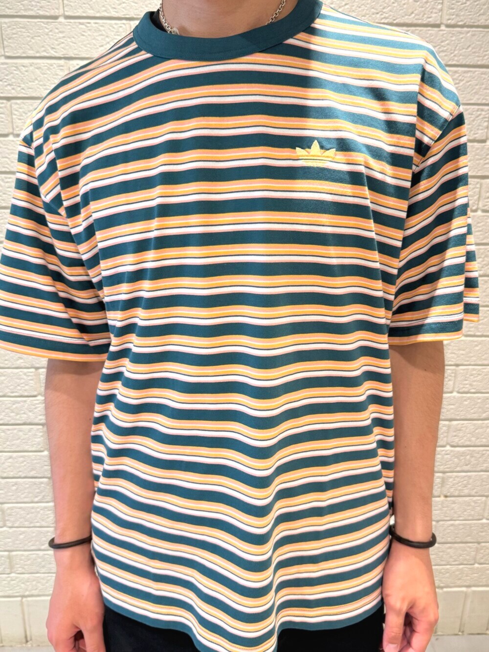 ブルー系のスニーカー、グリーン系のTシャツ/カットソーを着用したメンズの春コーディネートの3枚目の写真