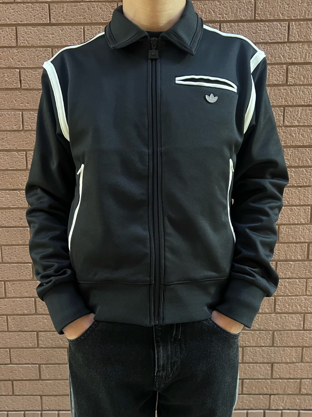 ブラック系のナイロンジャケット、ブラック系のシューズ、ブラック系のデニムパンツを着用したメンズの冬コーディネートの2枚目の写真