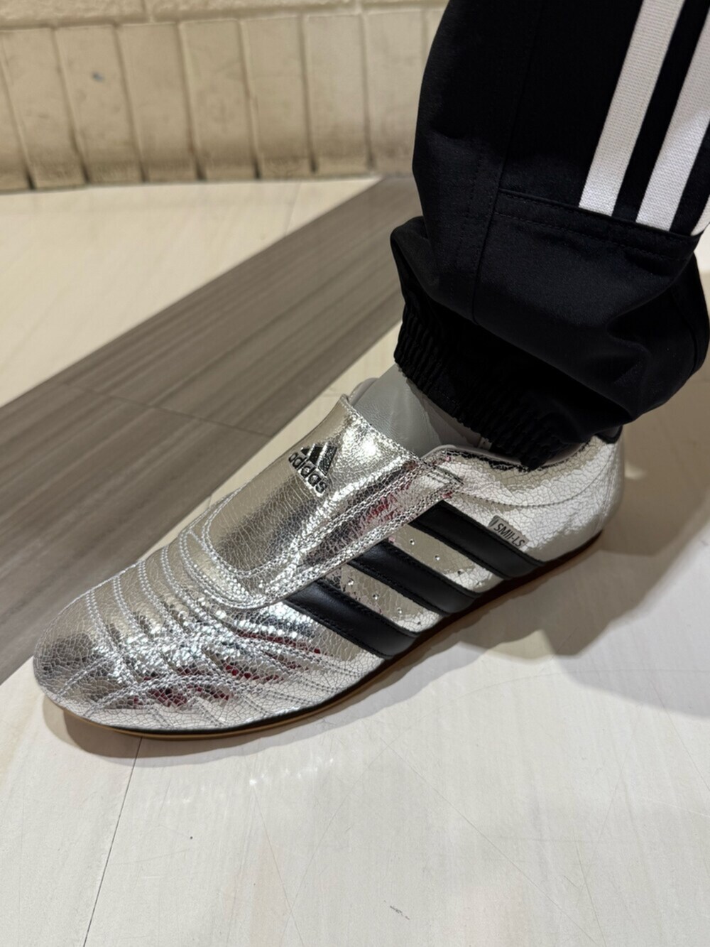 シルバー系のシューズ、ブラック系のパンツ、ブラック系のトップスを着用したメンズの冬コーディネートの4枚目の写真