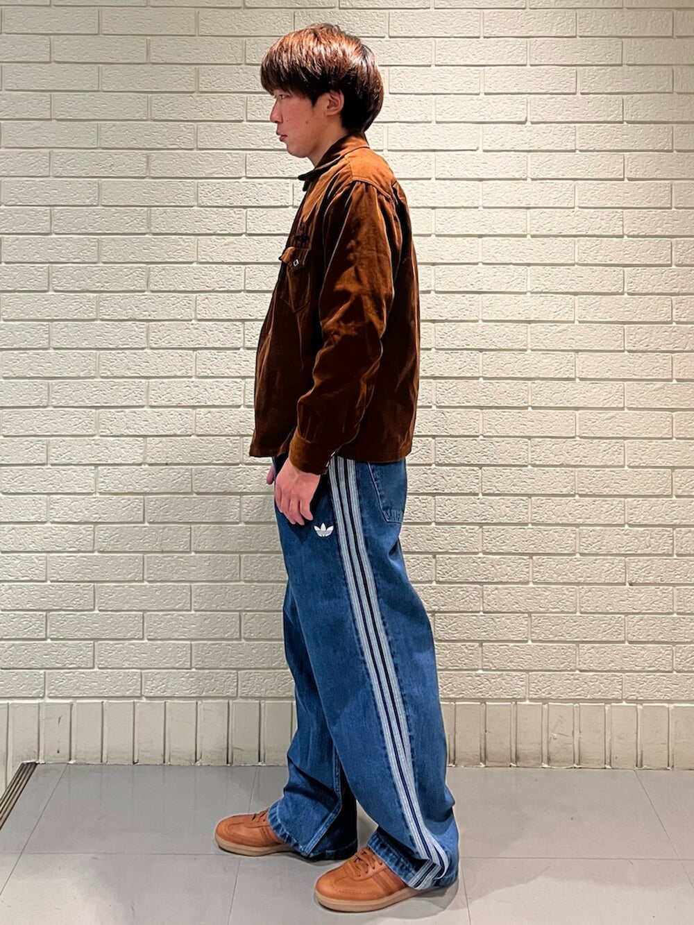 ブルー系のデニムパンツ、レッド系のシューズを着用したメンズの春コーディネートの2枚目の写真