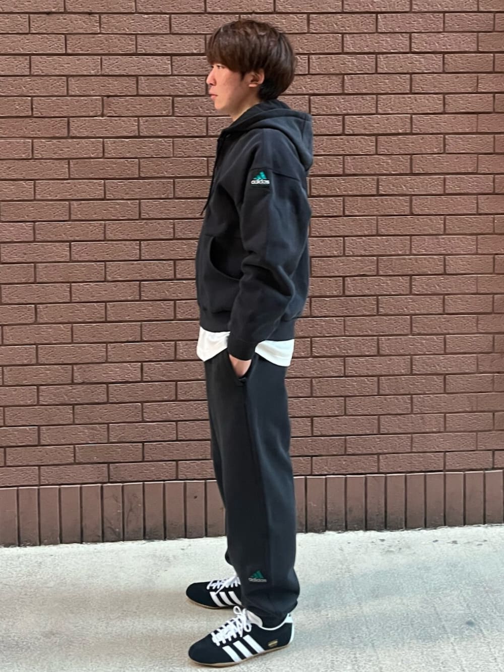 ブラック系のトップス、ブラック系のパンツ、ブラック系のスニーカーを着用したメンズの冬コーディネートの2枚目の写真