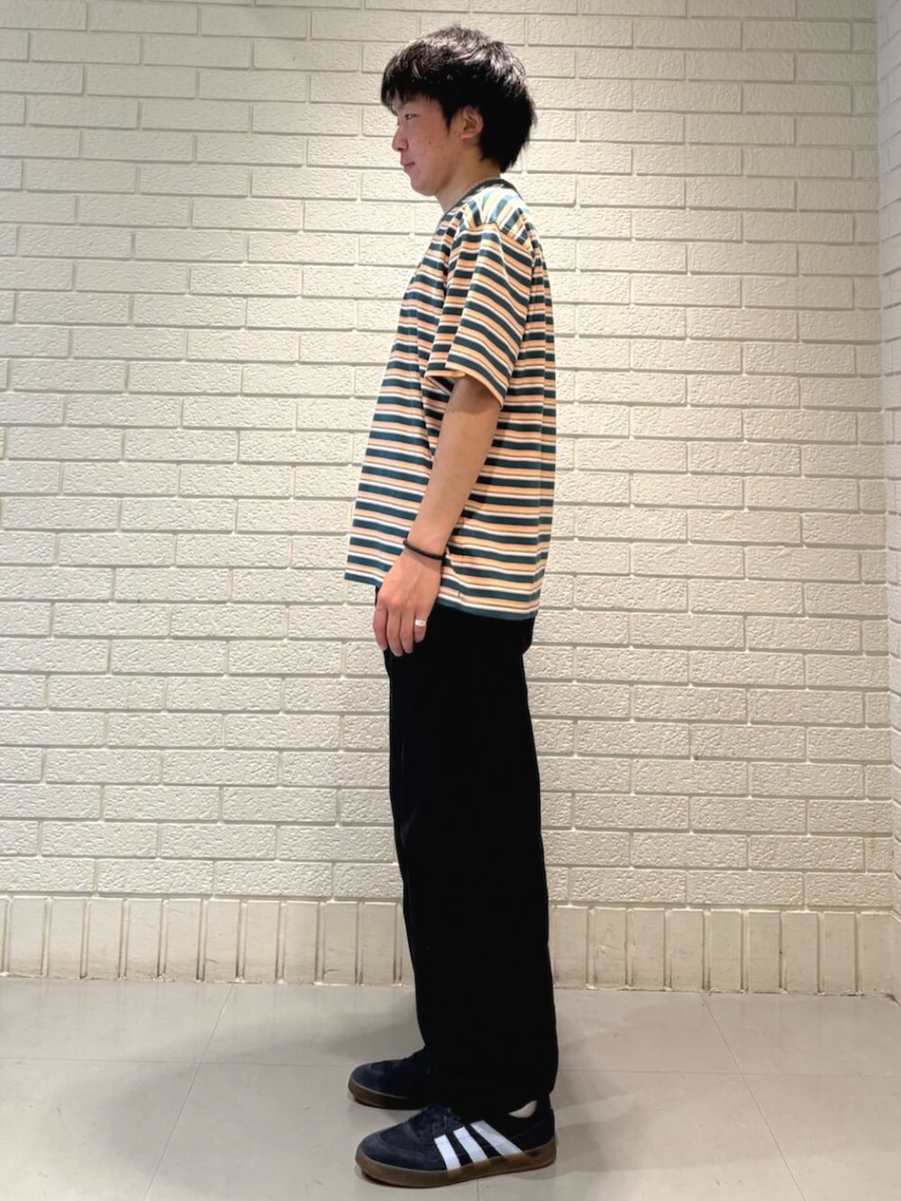 ブルー系のスニーカー、グリーン系のTシャツ/カットソーを着用したメンズの春コーディネートの2枚目の写真