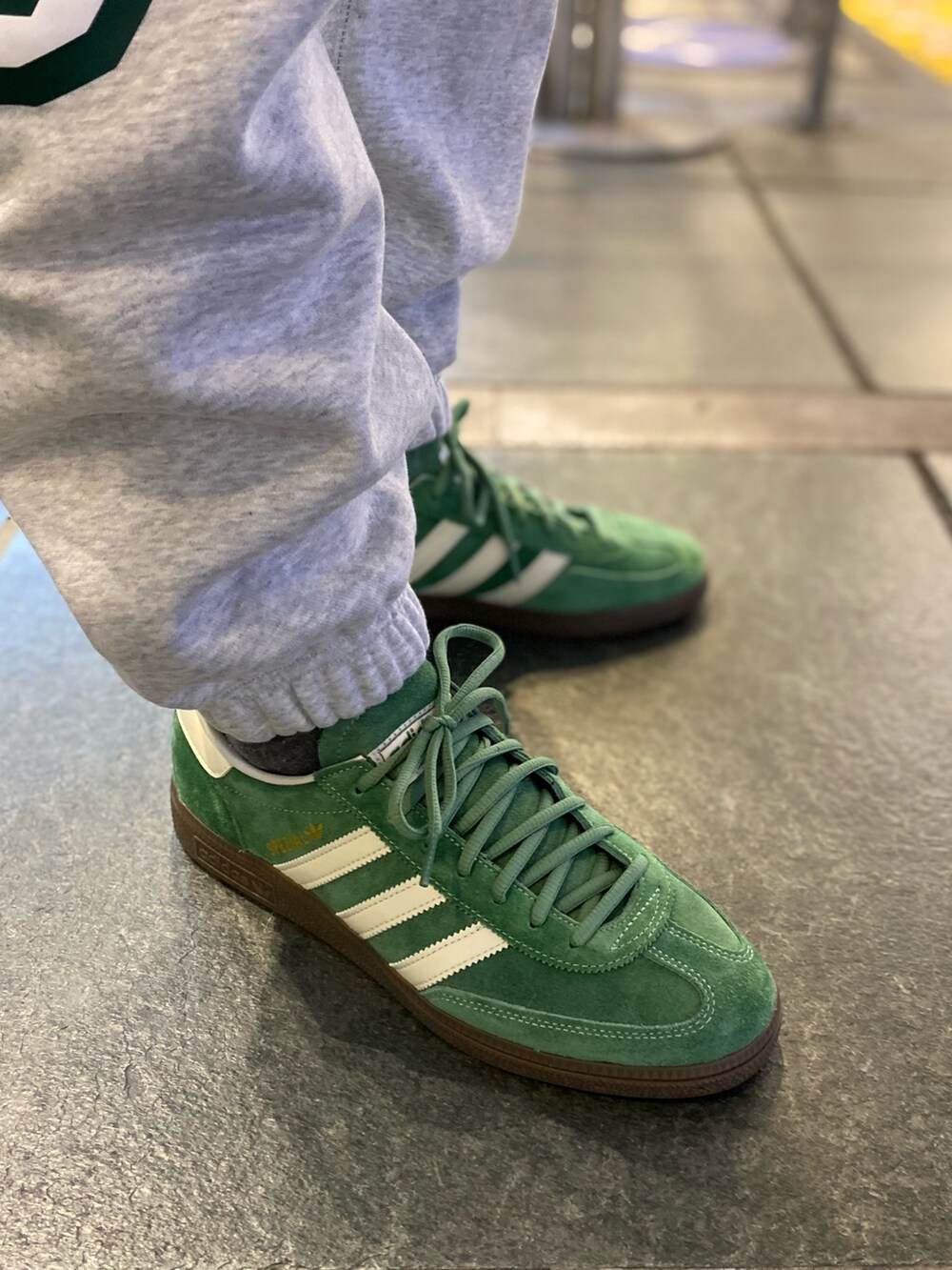 ブラック系のジャージ、グリーン系のショルダーバッグ、グレー系のスウェットパンツを着用したメンズの春コーディネートの4枚目の写真