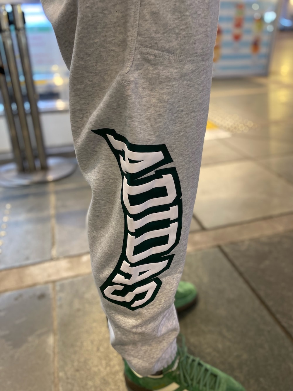 ブラック系のジャージ、グリーン系のショルダーバッグ、グレー系のスウェットパンツを着用したメンズの春コーディネートの3枚目の写真