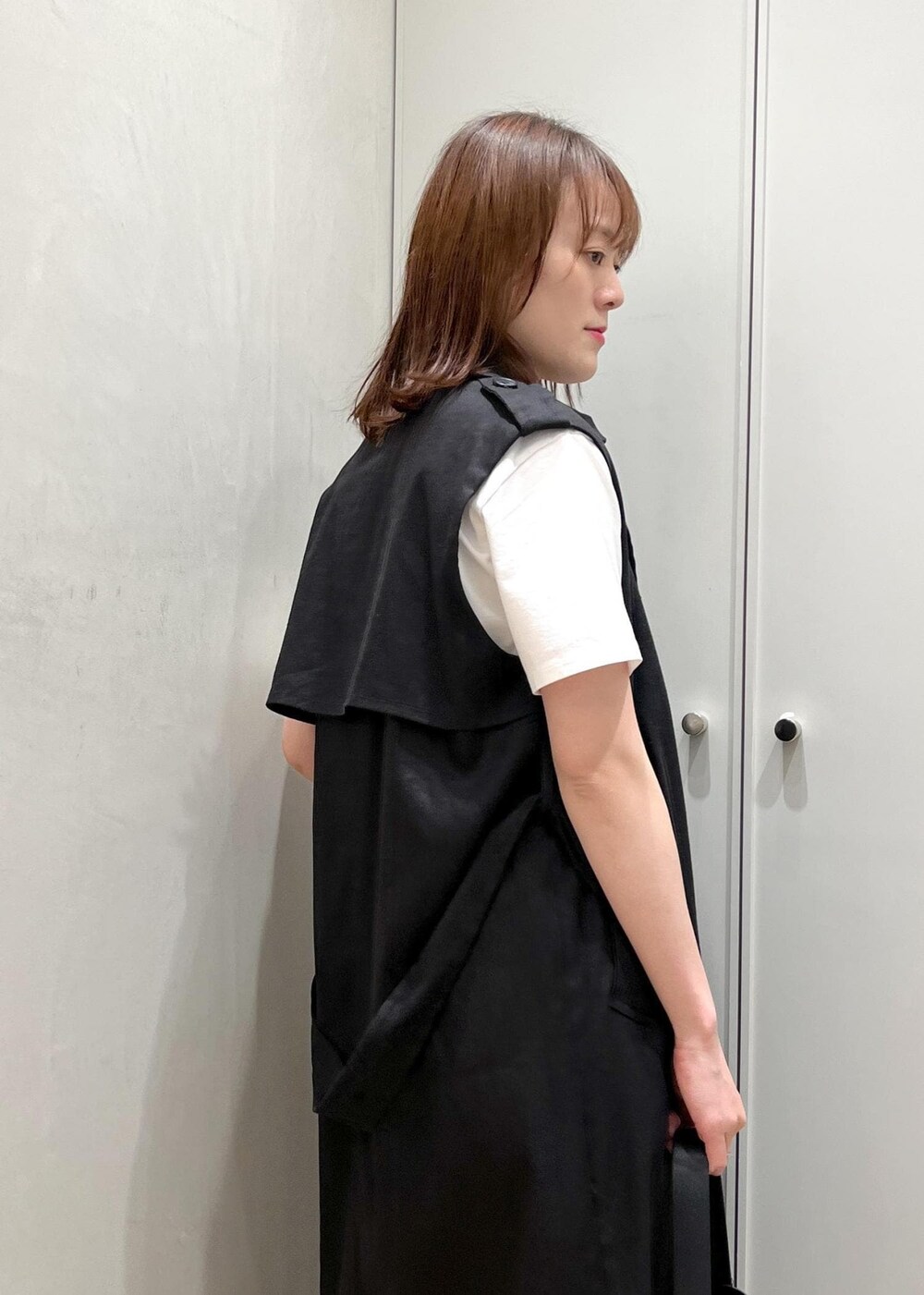 シルバー系のサンダル、ブラック系のハンドバッグ、ブルー系のデニムパンツを着用したレディースの夏コーディネートの3枚目の写真