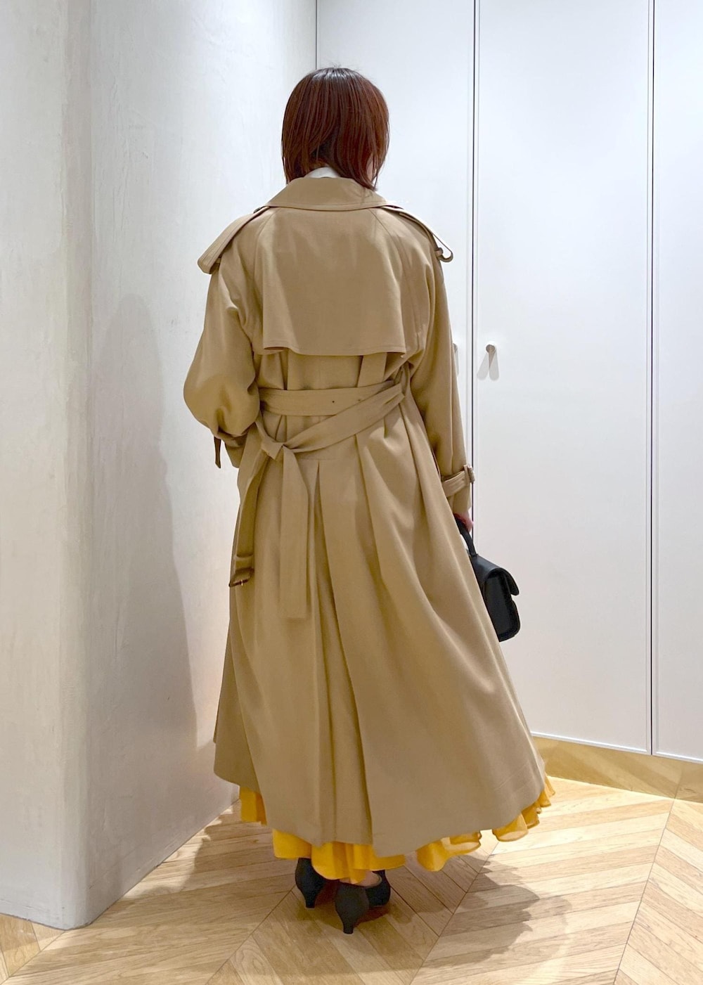 ブラック系のパンプス、オレンジ系のスカート、ホワイト系のシャツ/ブラウスを着用したレディースの春コーディネートの5枚目の写真