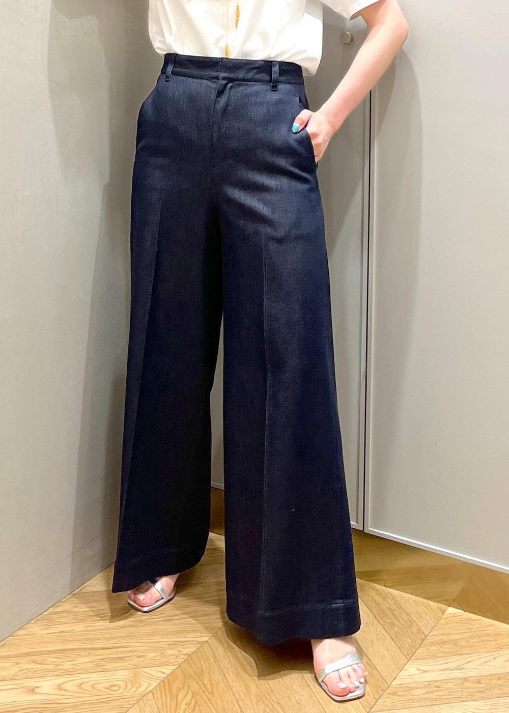 シルバー系のサンダル、ブラック系のハンドバッグ、ブルー系のデニムパンツを着用したレディースの夏コーディネートの7枚目の写真