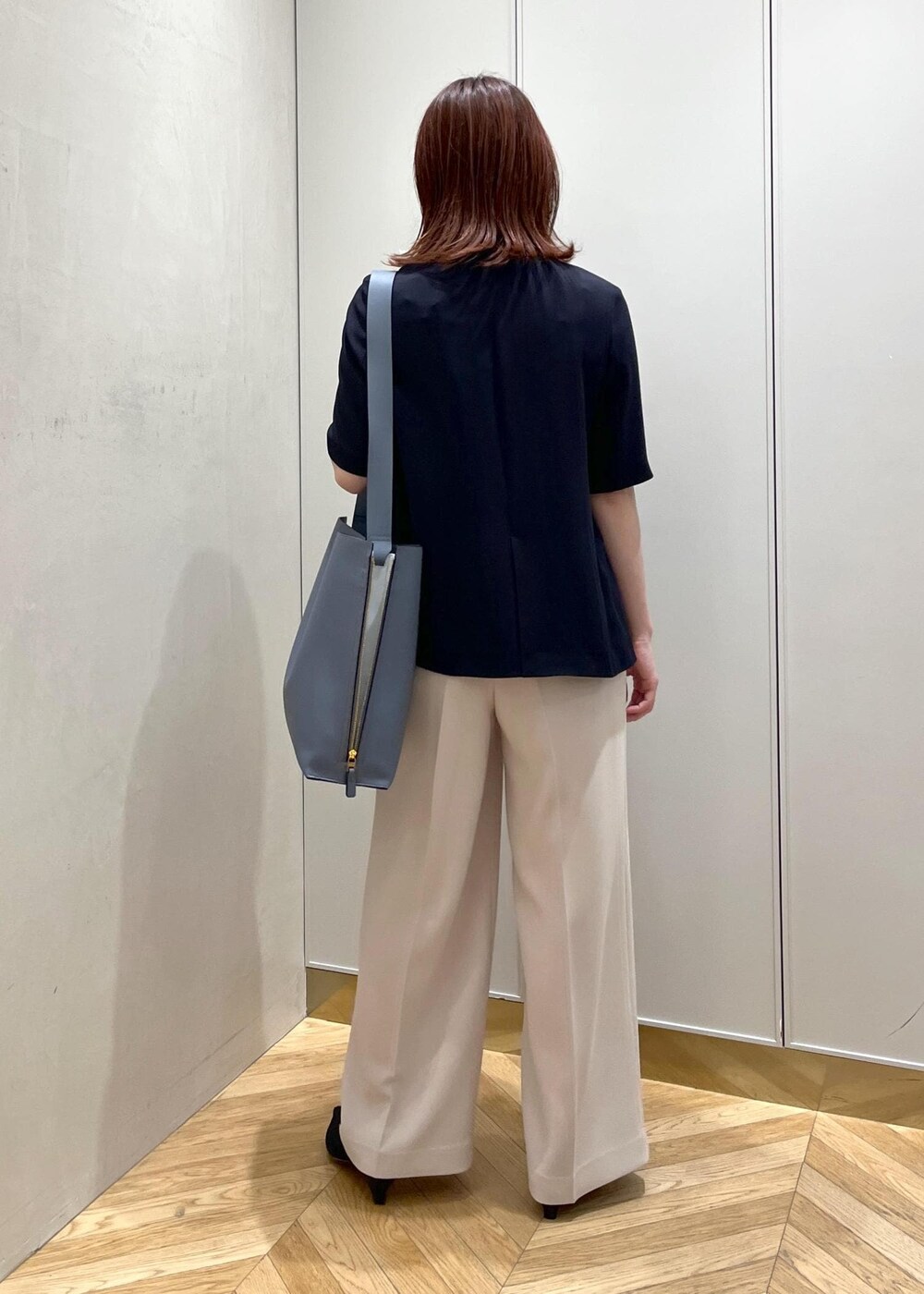 ブルー系のショルダーバッグ、ブラック系のパンプス、ベージュ系のその他パンツを着用したレディースの夏コーディネートの3枚目の写真