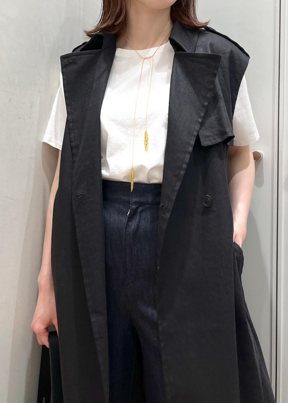 シルバー系のサンダル、ブラック系のハンドバッグ、ブルー系のデニムパンツを着用したレディースの夏コーディネートの4枚目の写真