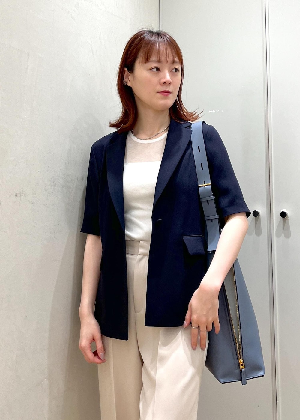 ブルー系のショルダーバッグ、ブラック系のパンプス、ベージュ系のその他パンツを着用したレディースの夏コーディネートの5枚目の写真