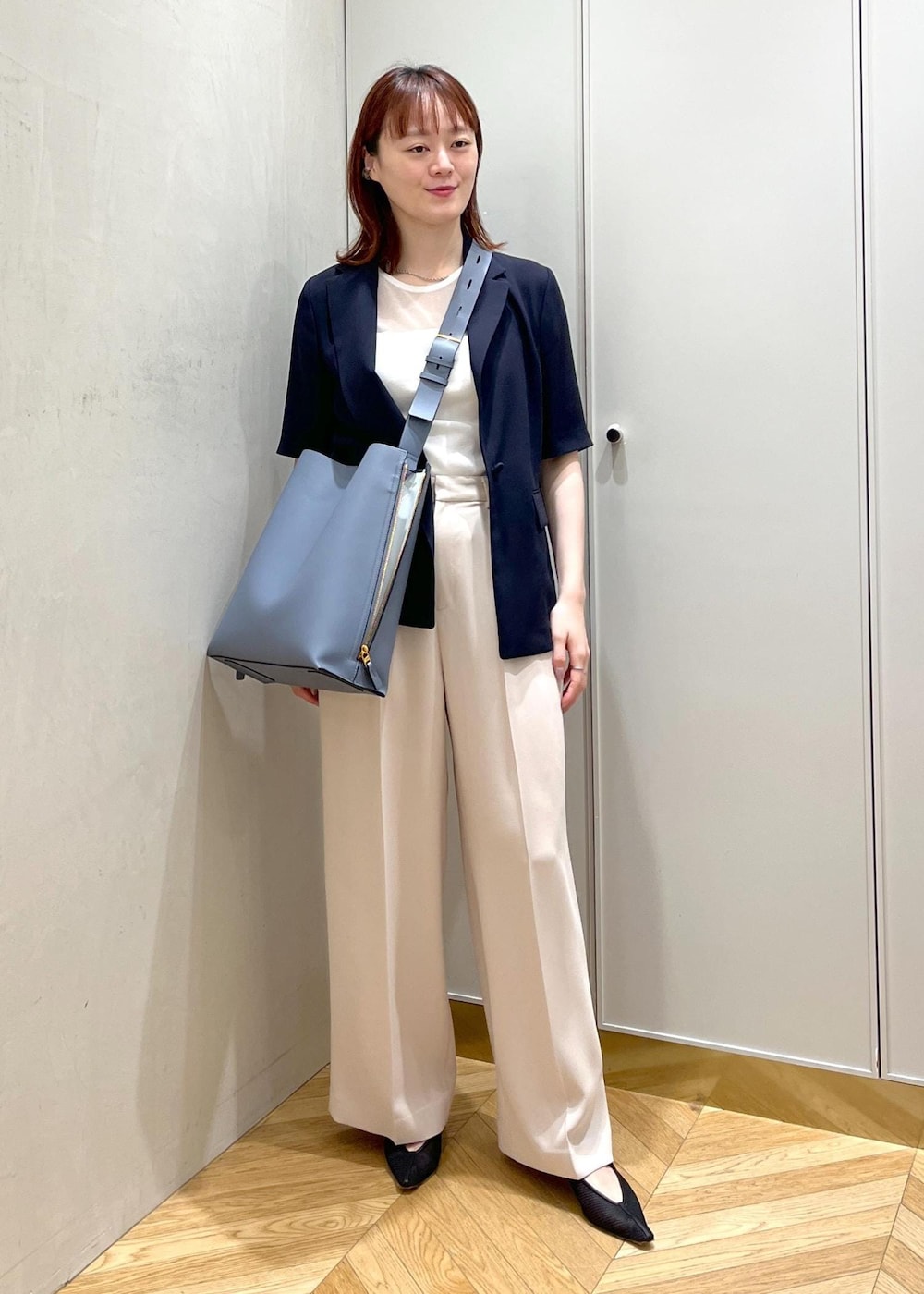 ブルー系のショルダーバッグ、ブラック系のパンプス、ベージュ系のその他パンツを着用したレディースの夏コーディネートの4枚目の写真