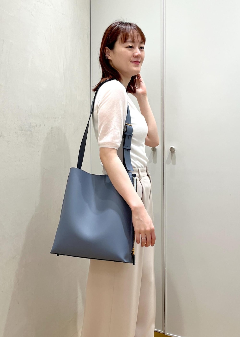 ブルー系のショルダーバッグ、ブラック系のパンプス、ベージュ系のその他パンツを着用したレディースの夏コーディネートの7枚目の写真