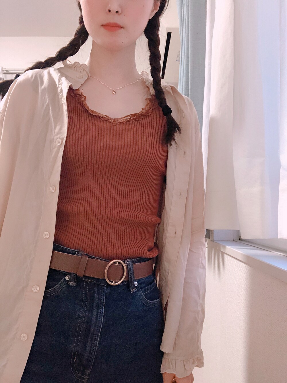 ブラウン系のタンクトップ、ベージュ系のシャツ/ブラウス、ブルー系のデニムパンツを着用したレディースの春コーディネートの2枚目の写真