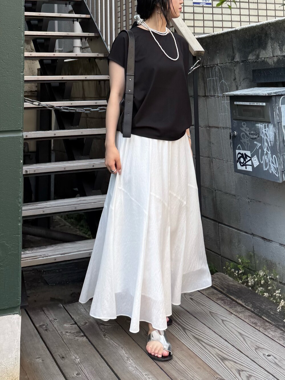 ブラック系のTシャツ/カットソー、ホワイト系のスカートを着用したレディースの夏コーディネートの5枚目の写真