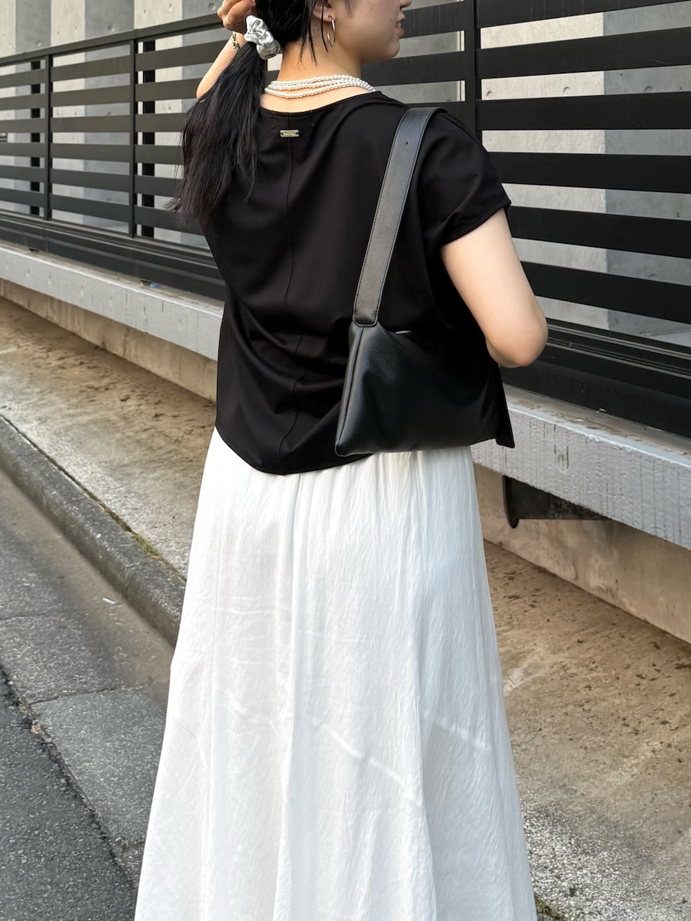 ブラック系のTシャツ/カットソー、ホワイト系のスカートを着用したレディースの夏コーディネートの3枚目の写真