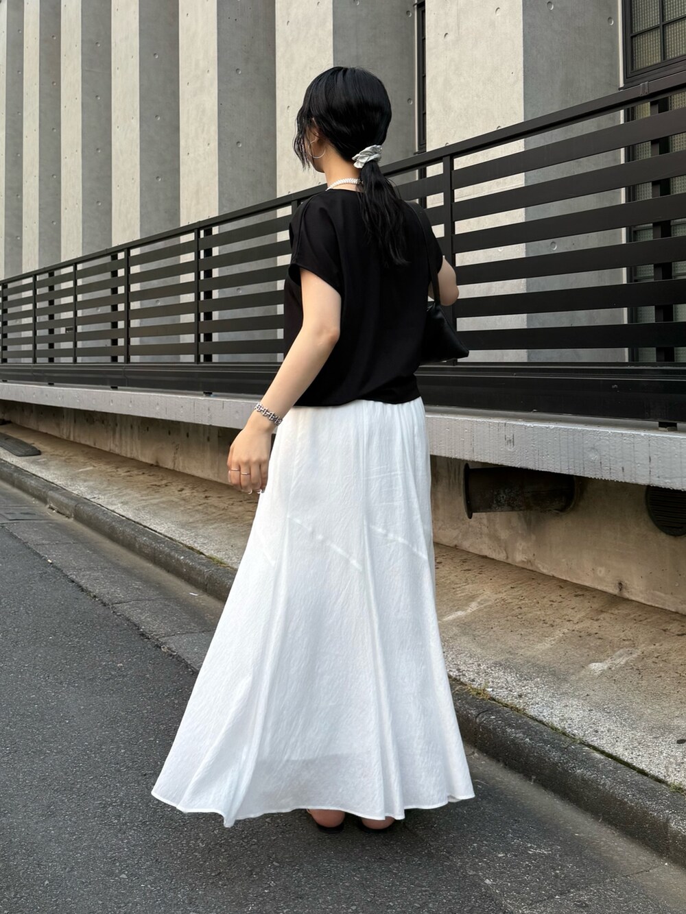 ブラック系のTシャツ/カットソー、ホワイト系のスカートを着用したレディースの夏コーディネートの2枚目の写真