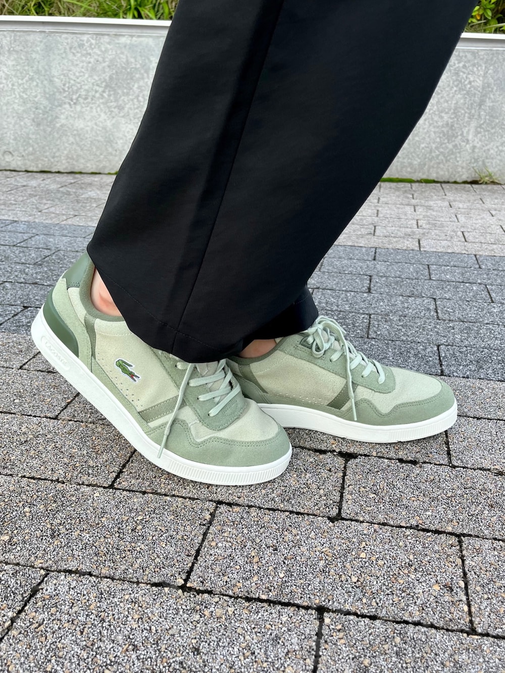 グリーン系のカーディガン/ボレロ、ホワイト系のTシャツ/カットソー、グリーン系のバッグを着用したメンズの春コーディネートの4枚目の写真