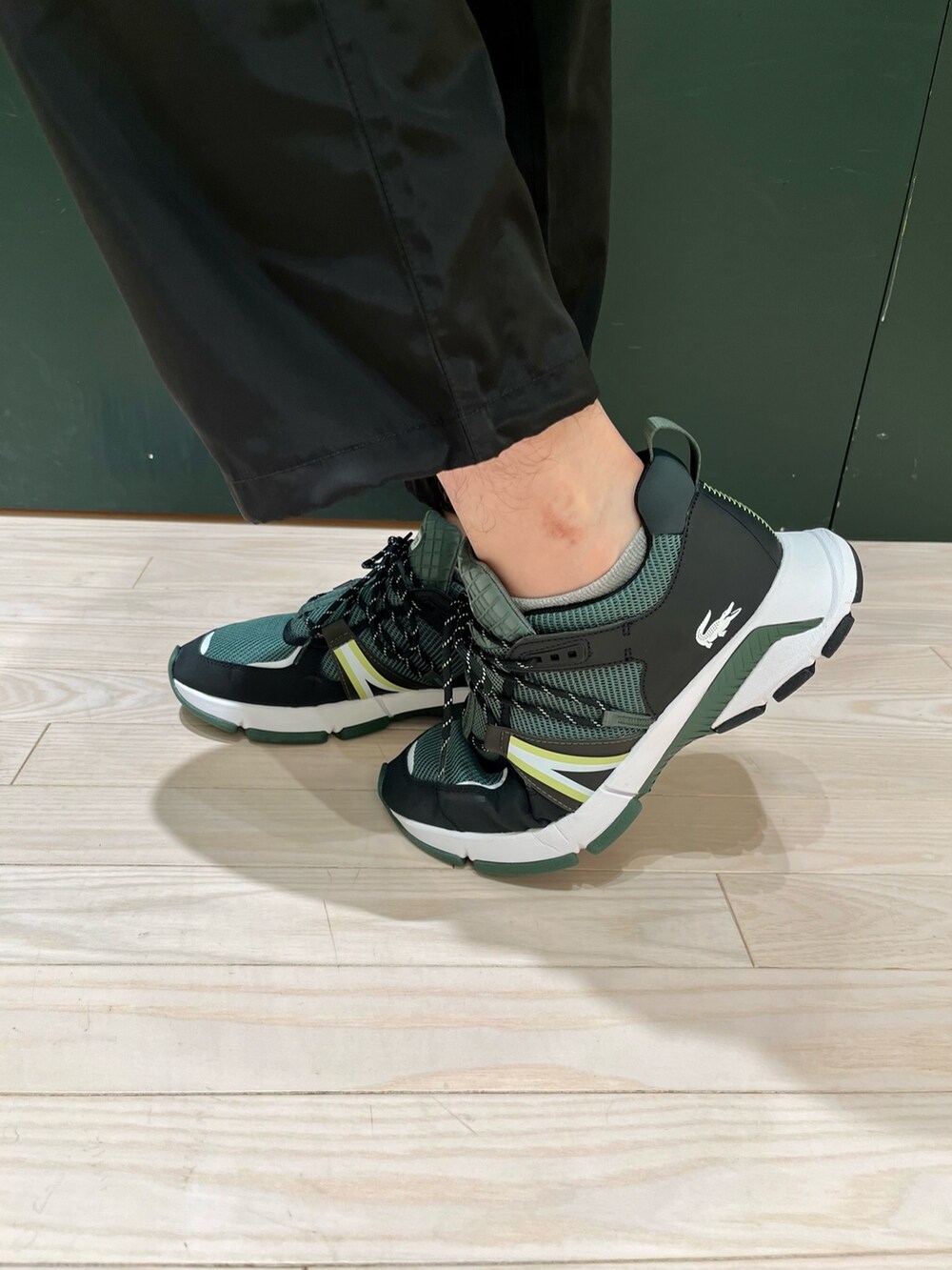 ホワイト系のスウェット、ブラウン系のブルゾン、ブラック系のカーゴパンツを着用したメンズの秋コーディネートの6枚目の写真