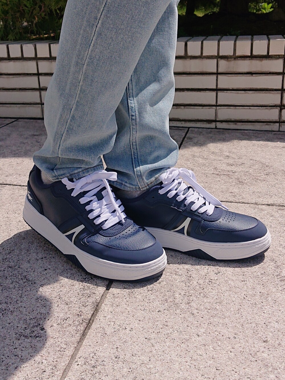 ブルー系のデニムパンツ、ブルー系のトートバッグ、ブルー系のスニーカーを着用したメンズの春コーディネートの4枚目の写真