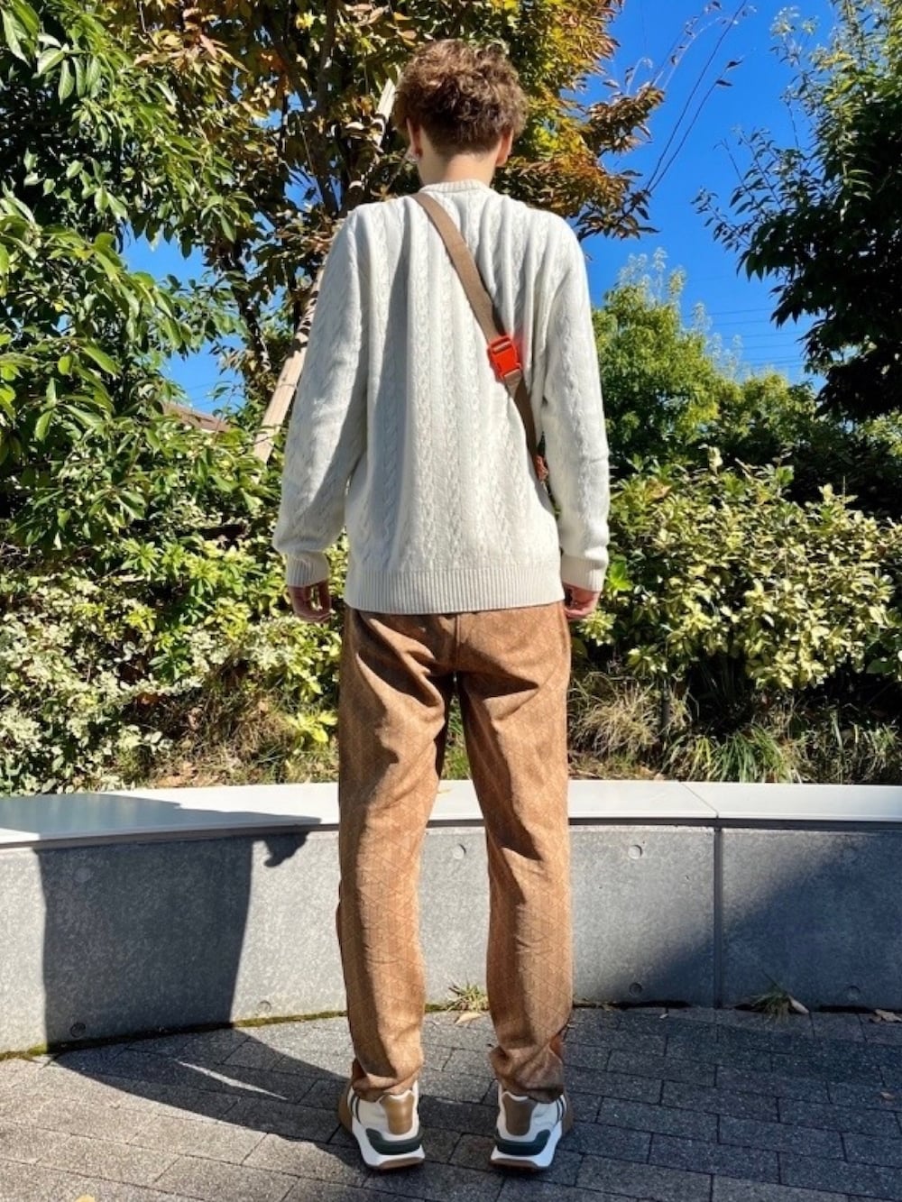 ベージュ系のその他パンツ、ベージュ系のスニーカー、ホワイト系のニット/セーターを着用したメンズの春コーディネートの4枚目の写真