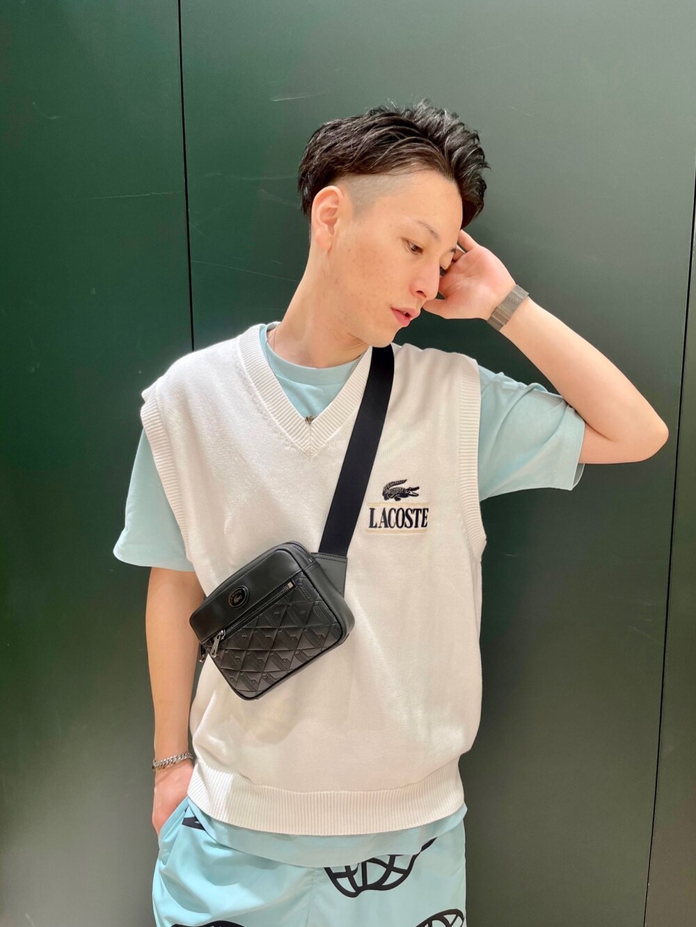 ホワイト系のベスト、ブルー系のTシャツ/カットソー、ホワイト系のスニーカーを着用したメンズの秋コーディネートの3枚目の写真