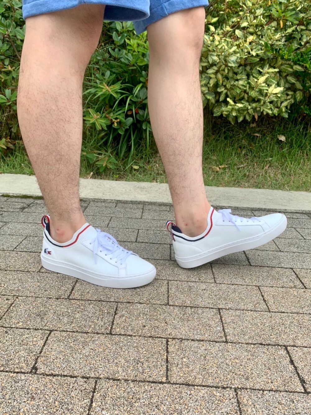 ホワイト系のTシャツ/カットソー、ブルー系のその他パンツ、ホワイト系のスニーカーを着用したメンズの春コーディネートの5枚目の写真