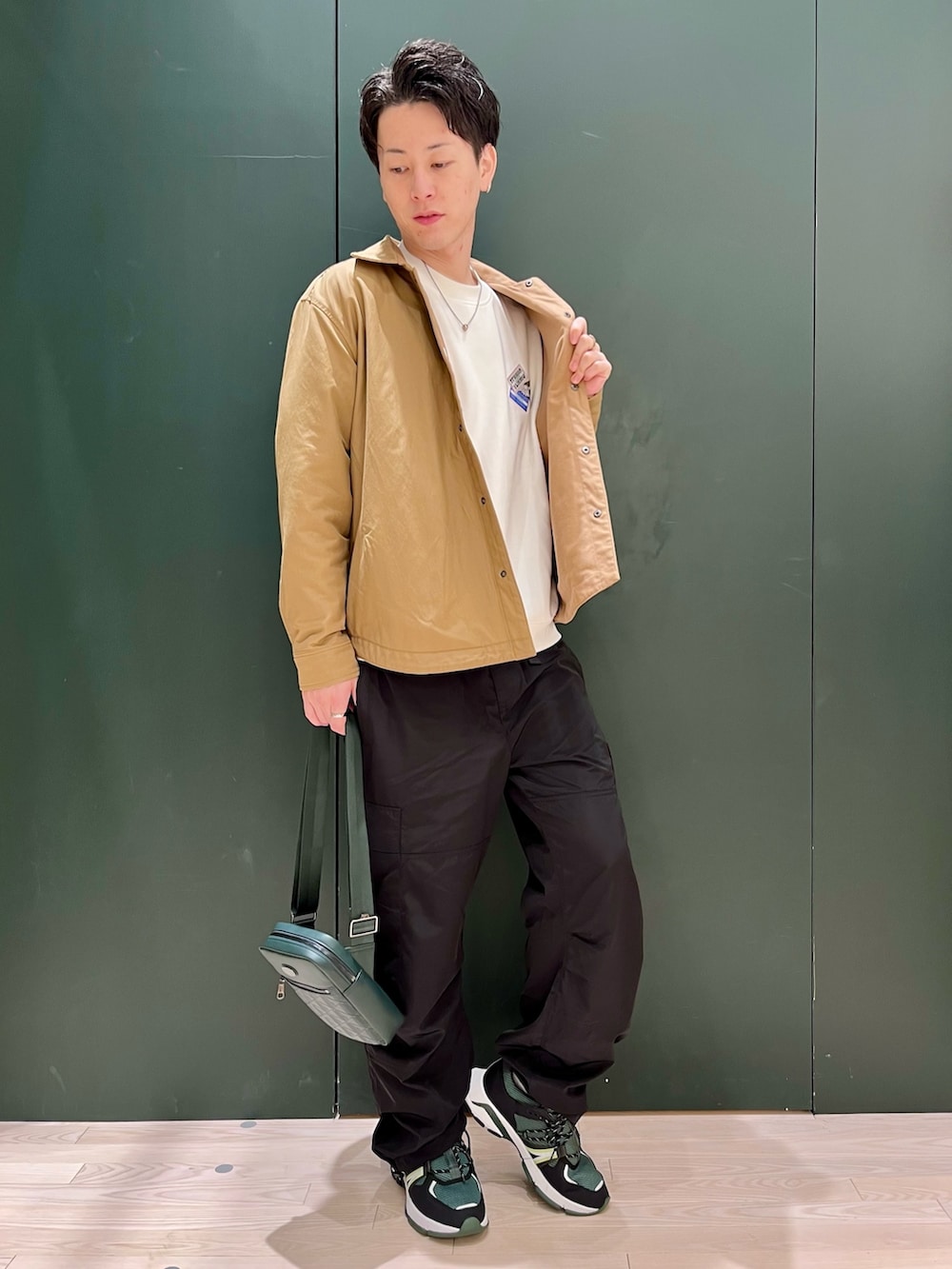 ホワイト系のスウェット、ブラウン系のブルゾン、ブラック系のカーゴパンツを着用したメンズの秋コーディネートの2枚目の写真