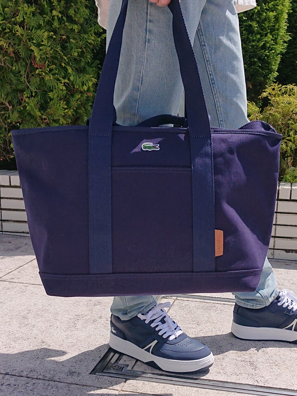 ブルー系のデニムパンツ、ブルー系のトートバッグ、ブルー系のスニーカーを着用したメンズの春コーディネートの5枚目の写真